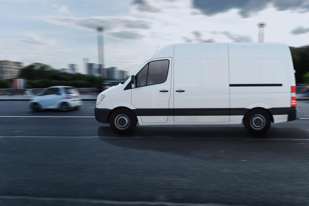 A DHLtruck speeding down the highway.