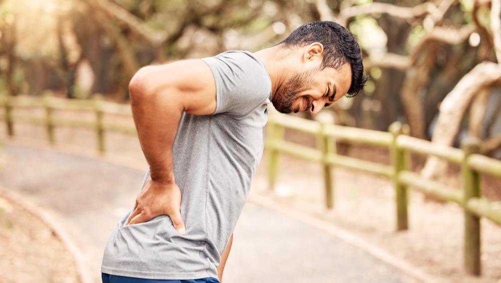 A man holding his back, wondering what the average spinal cord injury is.