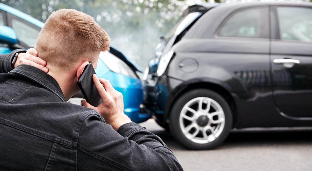 A man on his phone after a rear-end car crash in Orem, UT.