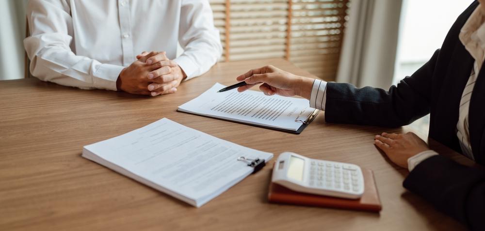 A client sitting across from their lawyer with paperwork in front of them as they prepare to file a rideshare accident claim.
