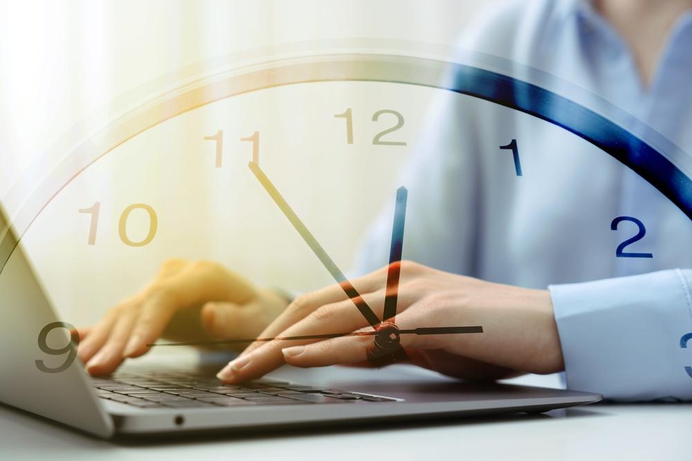 A lawyer works on a case on her laptop with a translucent clock in front of her to represent the personal injury statute of limitations in Idaho.