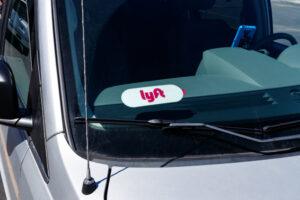 A close-up image of the Lyft sticker on a car’s window, which symbolizes the question of who you can sue after a Lyft accident.