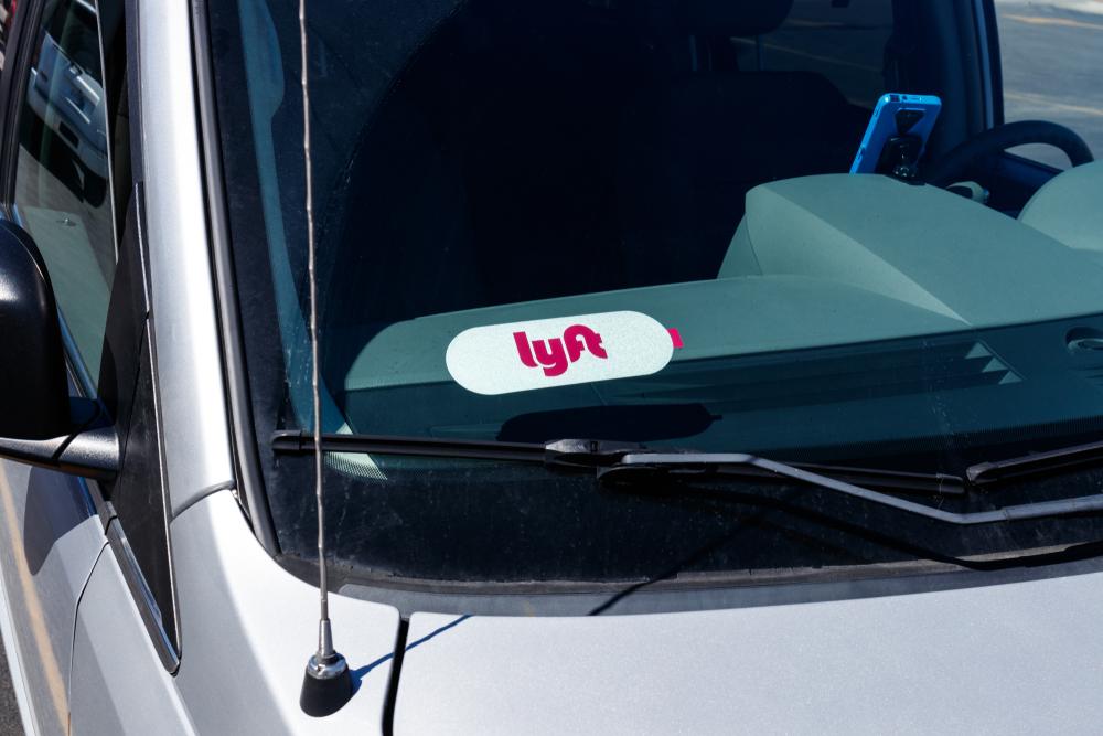 A close-up image of the Lyft sticker on a car’s window, which symbolizes the question of who you can sue after a Lyft accident.