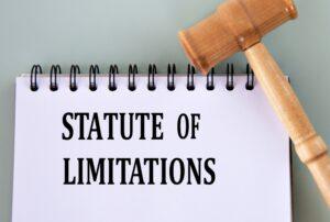 Aerial view of a gavel and a spiral notebook with the words “statute of limitations” written on it to symbolize the car accident statute of limitations in Utah.