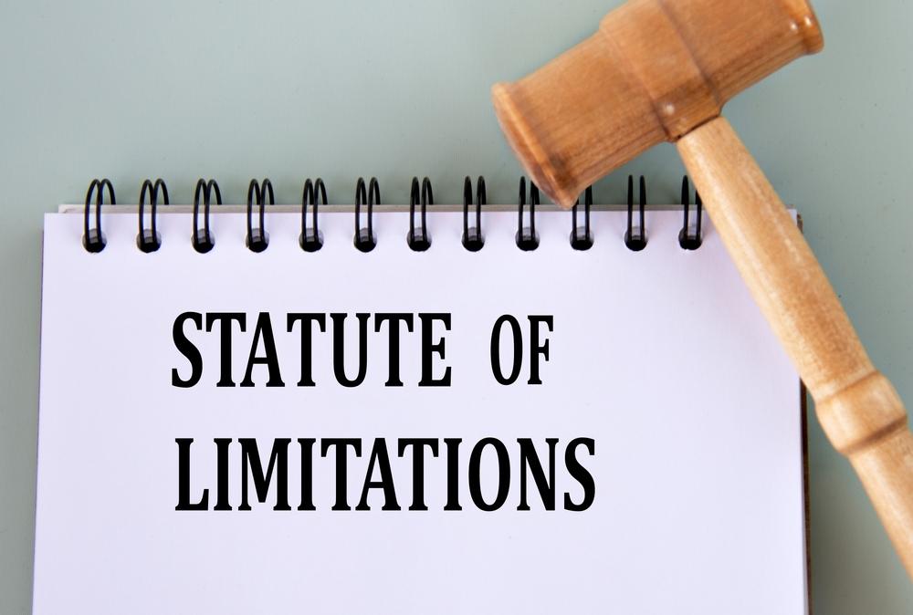 Aerial view of a gavel and a spiral notebook with the words “statute of limitations” written on it to symbolize the car accident statute of limitations in Utah.