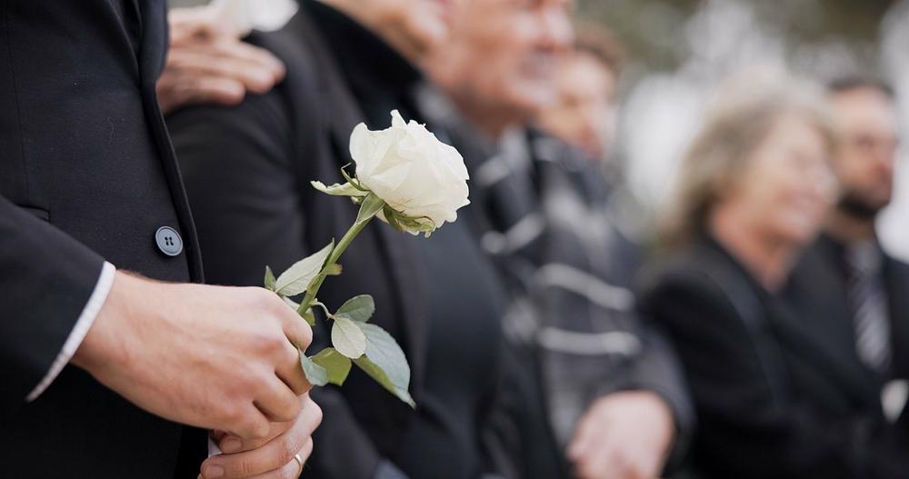A man holding a white rose at a funeral. What is the wrongful death statute of limitations in Washington?