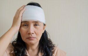 A woman with her head wrapped, wondering if she can sue for a concussion.