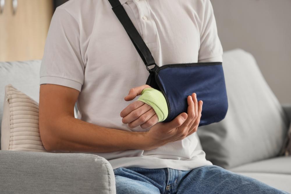 A man in a cast, wondering what happens if medical bills exceed your PIP coverage in Utah