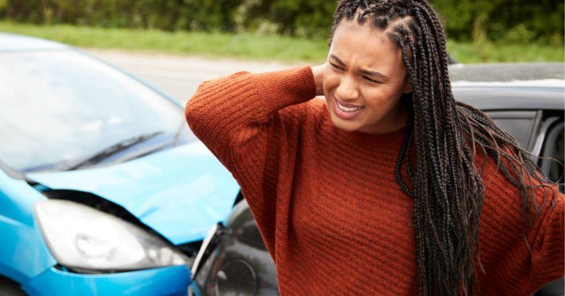 A woman holding her neck after a car accident. How long will insurers pay for a rental car after an accident?